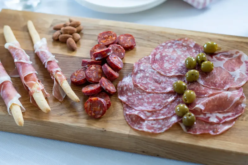 Wurstplatte aus der Metzgerei auf Holzbrett mit Salami und Schinken